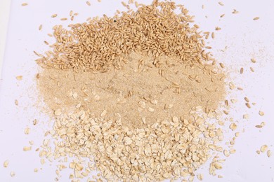 Photo of Oat bran, grains and flakes on white background, top view