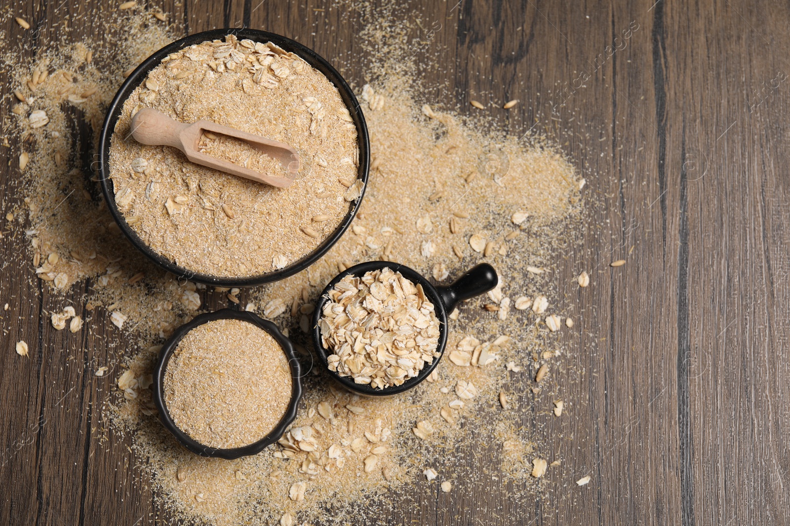 Photo of Oat bran and flakes on wooden table, flat lay