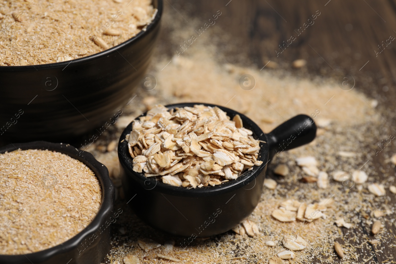 Photo of Oat bran and flakes on table, closeup