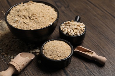 Photo of Oat bran and flakes on wooden table