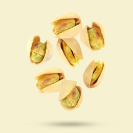 Image of Tasty pistachios in air on color background