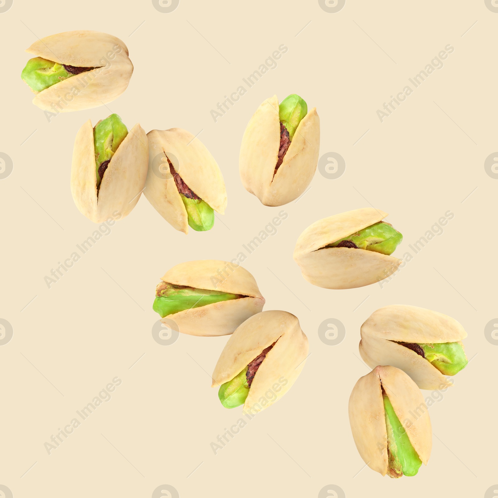 Image of Tasty pistachios in air on color background