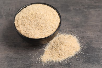 Oat bran in bowl on grey table, closeup