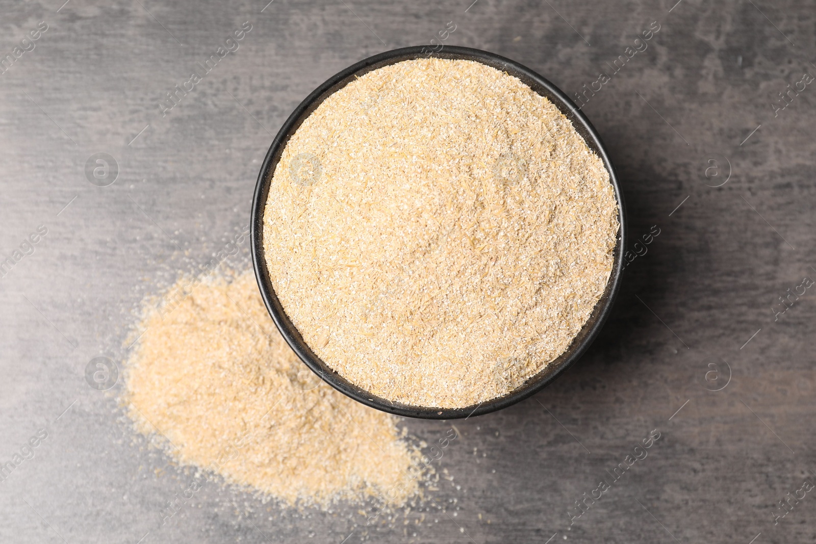 Photo of Oat bran in bowl on grey table, top view