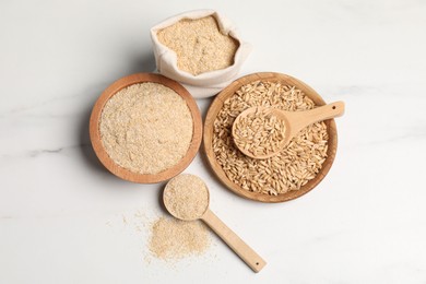 Photo of Oat bran and grains on white marble table, flat lay