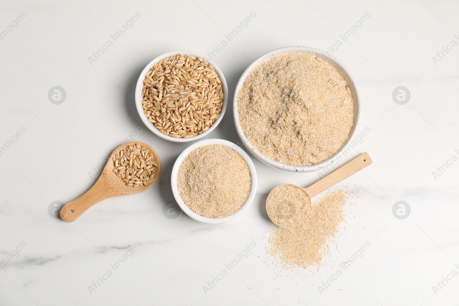 Photo of Oat bran and grains on white marble table, flat lay