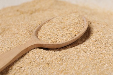 Photo of Pile of oat bran and wooden spoon, closeup