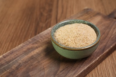 Photo of Oat bran in bowl on wooden table, closeup