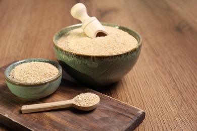 Photo of Oat bran in bowls, spoon and scoop on wooden table