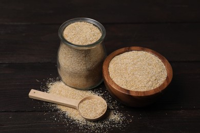 Photo of Oat bran in glass jar, bowl and spoon on wooden table