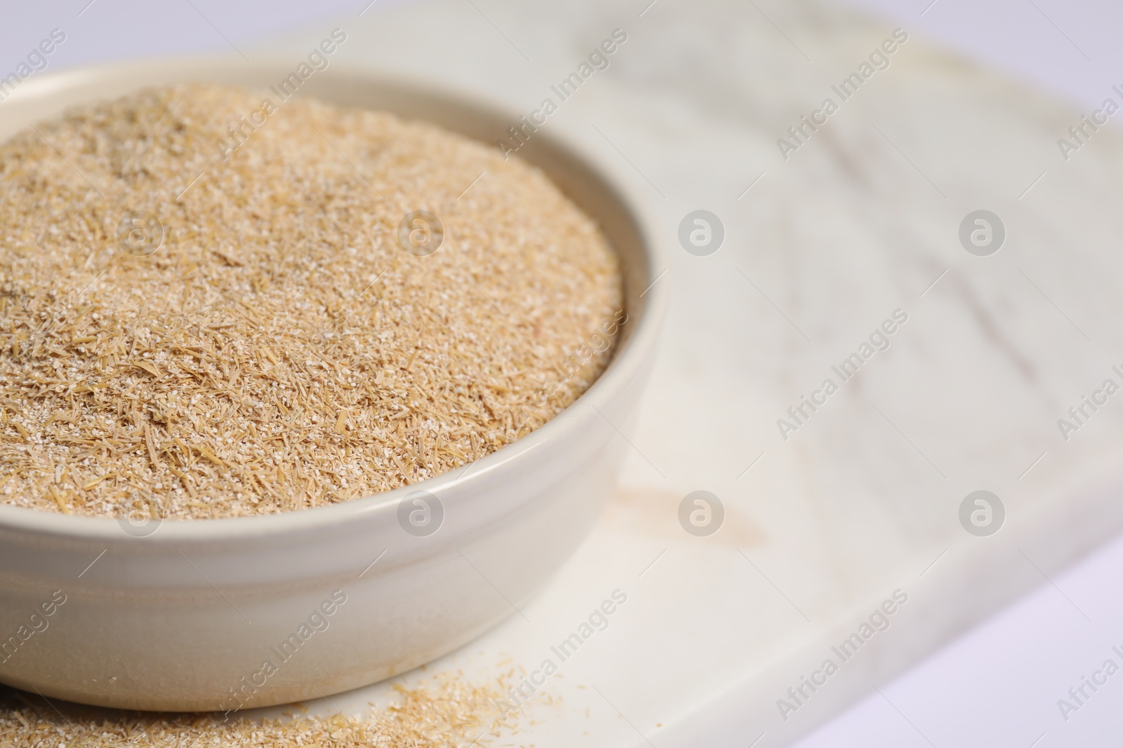 Photo of Oat bran in bowl on table, closeup. Space for text