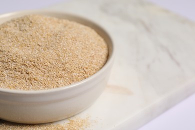 Photo of Oat bran in bowl on table, closeup. Space for text