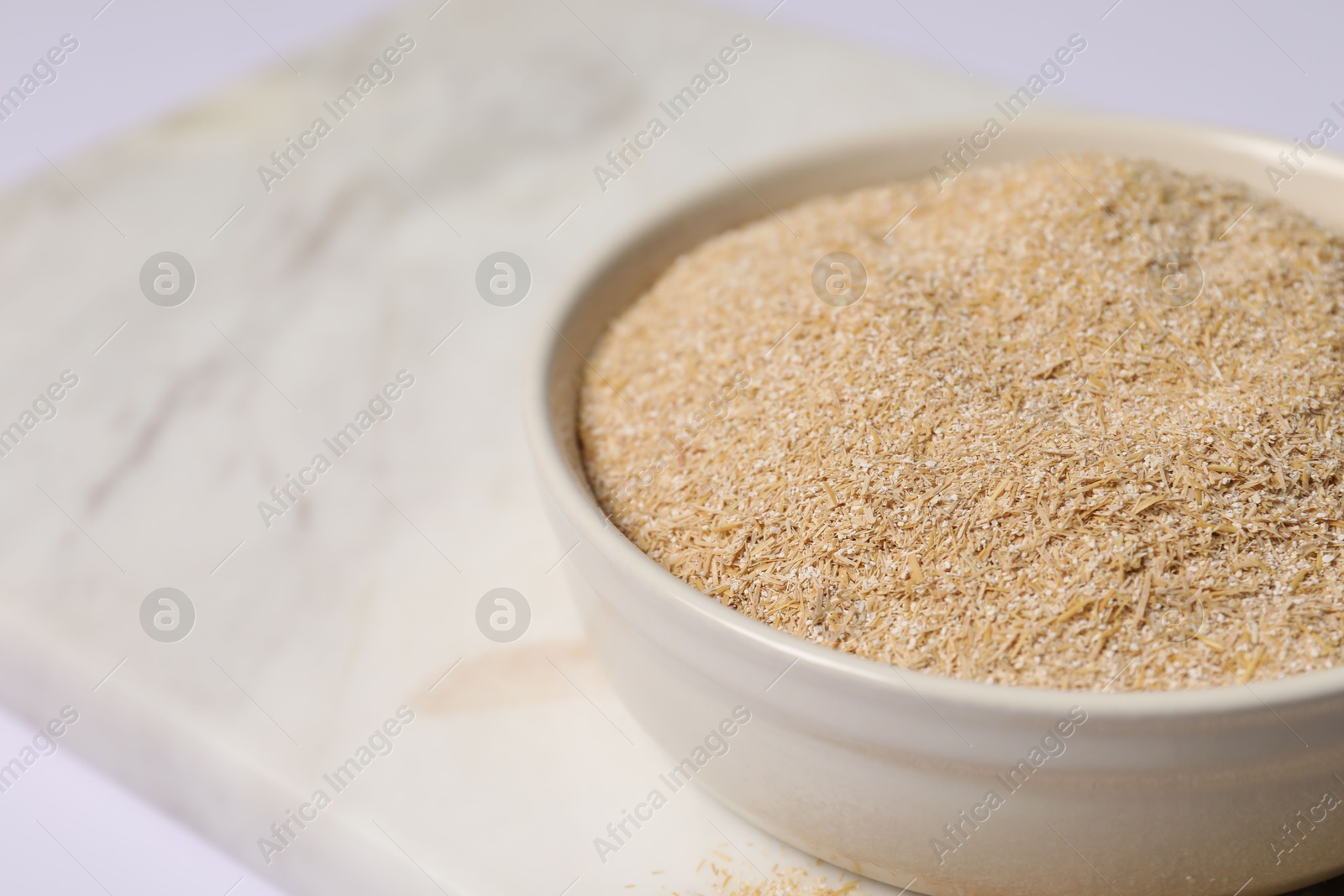 Photo of Oat bran in bowl on table, closeup. Space for text