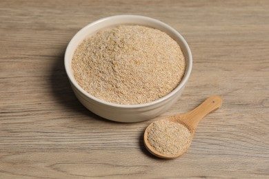 Photo of Oat bran in bowl and spoon on wooden table