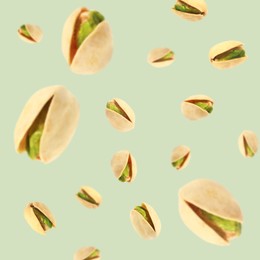 Image of Tasty pistachios in air on color background