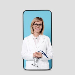 Image of Online medical consultation. Doctor with stethoscope on smartphone screen against white background