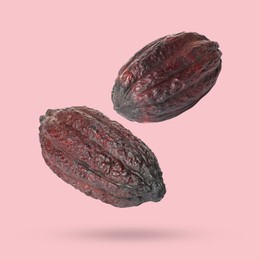 Image of Cocoa pods in air on pink background