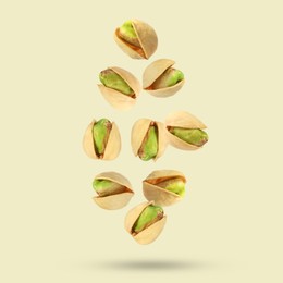 Image of Tasty pistachios in air on color background