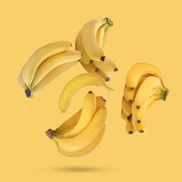 Image of Many fresh bananas falling on yellow background