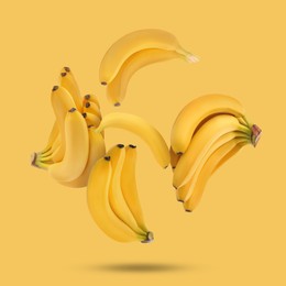 Image of Many fresh bananas falling on yellow background