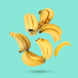 Many yellow bananas falling on turquoise background