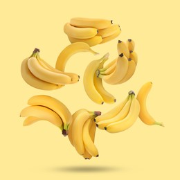 Image of Many fresh bananas falling on yellow background