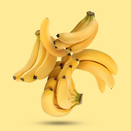 Image of Many fresh bananas falling on yellow background