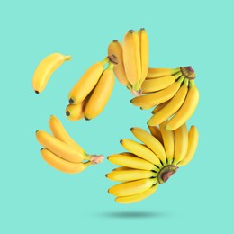 Image of Many yellow bananas falling on turquoise background