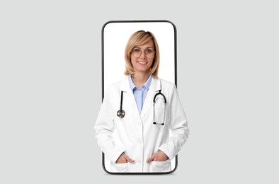 Online medical consultation. Doctor on smartphone screen against light grey background