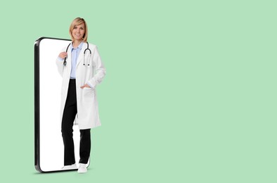 Online medical consultation. Doctor on smartphone screen against aquamarine color background, space for text