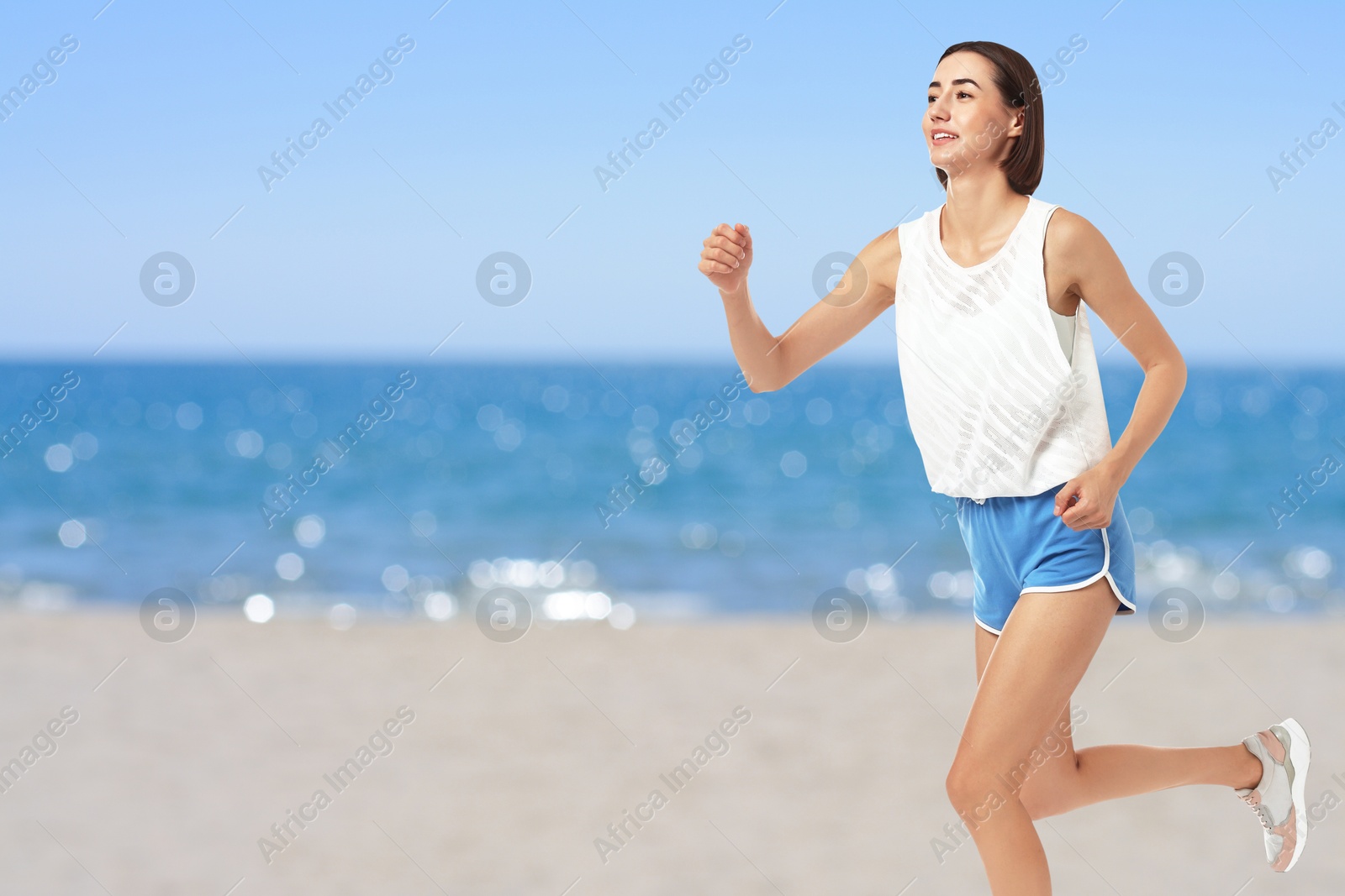 Image of Beautiful woman running on beach. Space for text