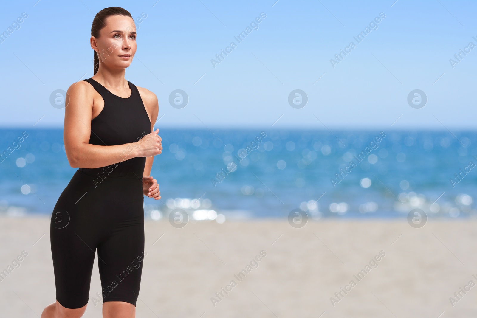 Image of Beautiful woman running on beach. Space for text