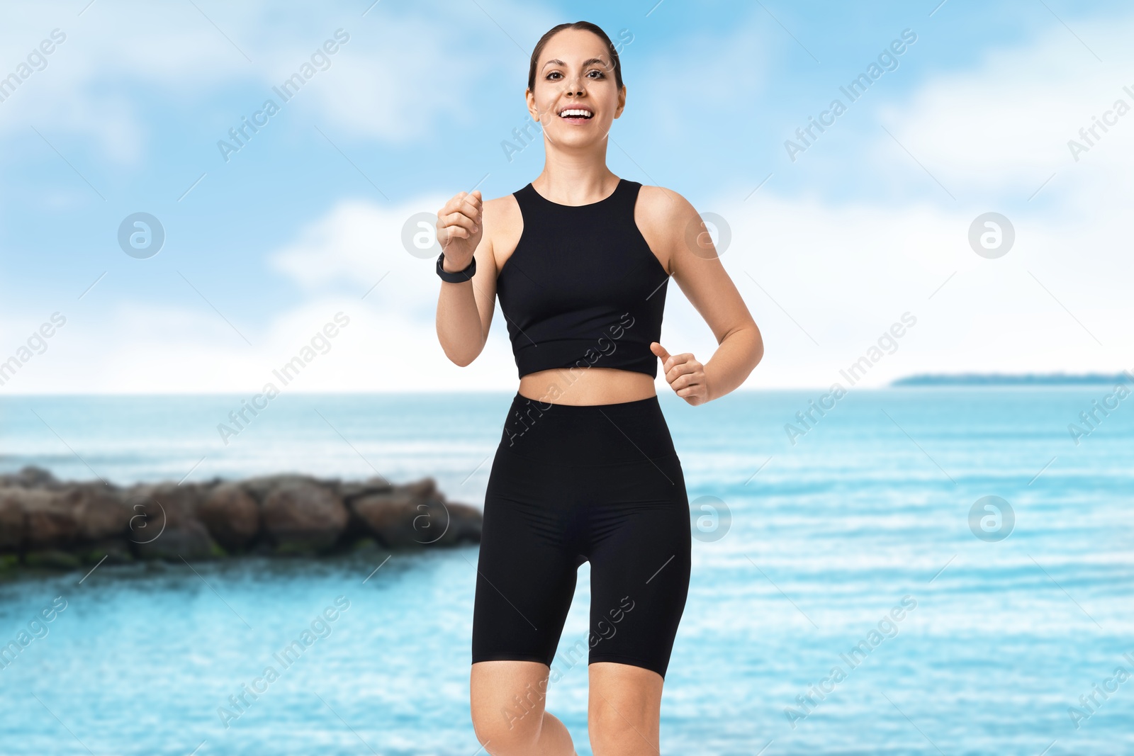 Image of Beautiful woman in sportive clothes running on beach