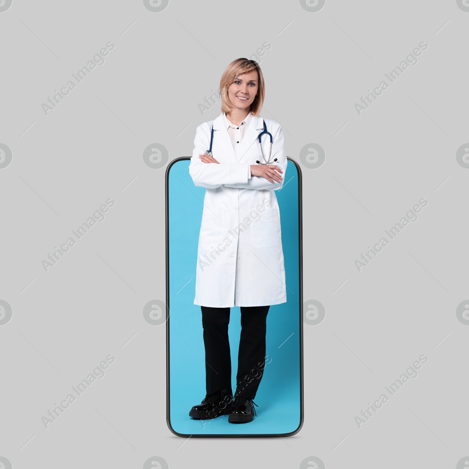 Image of Online medical consultation. Doctor on smartphone screen against light grey background