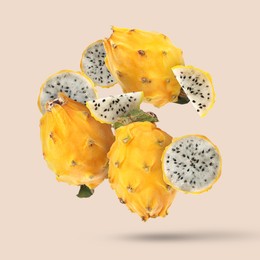 Image of Yummy yellow pitaya fruits falling on beige background