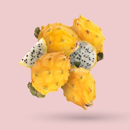 Image of Yummy yellow pitaya fruits falling on pink background