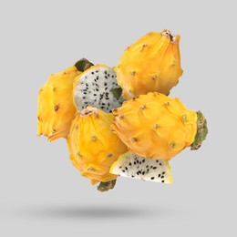 Image of Yummy yellow pitaya fruits falling on light grey background