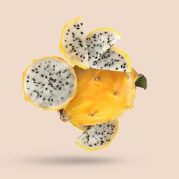 Image of Yummy yellow pitaya fruits falling on beige background