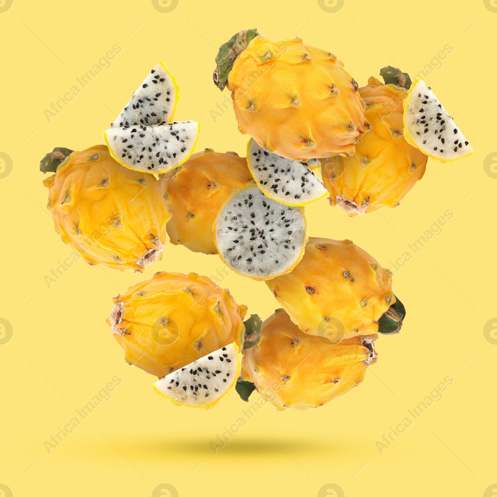 Image of Yummy pitaya fruits falling on yellow background