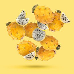 Image of Yummy pitaya fruits falling on yellow background