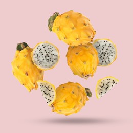 Image of Yummy yellow pitaya fruits falling on pink background