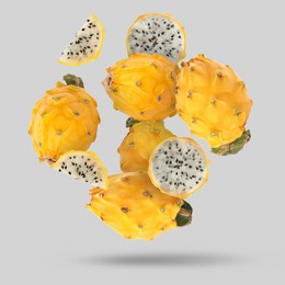 Image of Yummy yellow pitaya fruits falling on light grey background