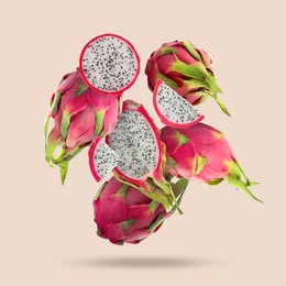 Image of Yummy pitaya fruits falling on beige background