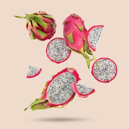 Image of Yummy pitaya fruits falling on beige background