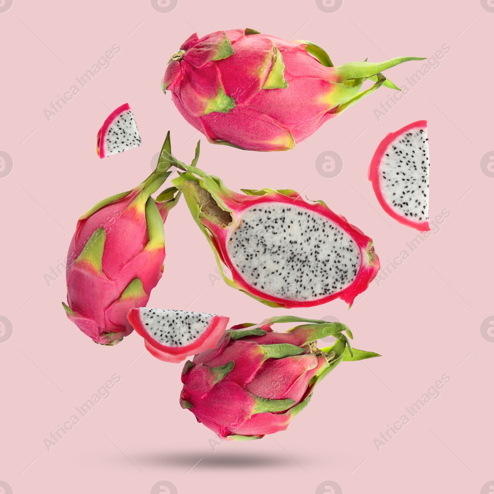 Image of Yummy pitaya fruits falling on pink background