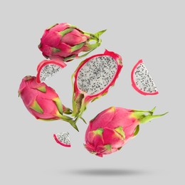 Image of Yummy pitaya fruits falling on light grey background