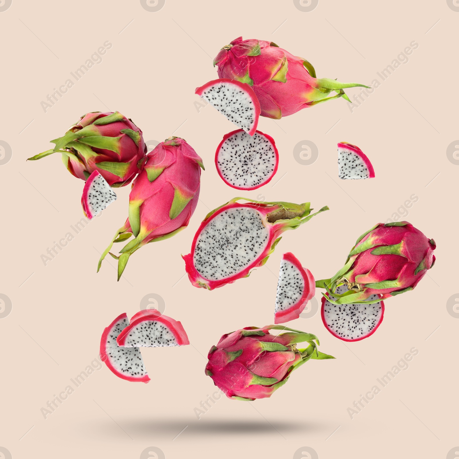 Image of Yummy pitaya fruits falling on beige background