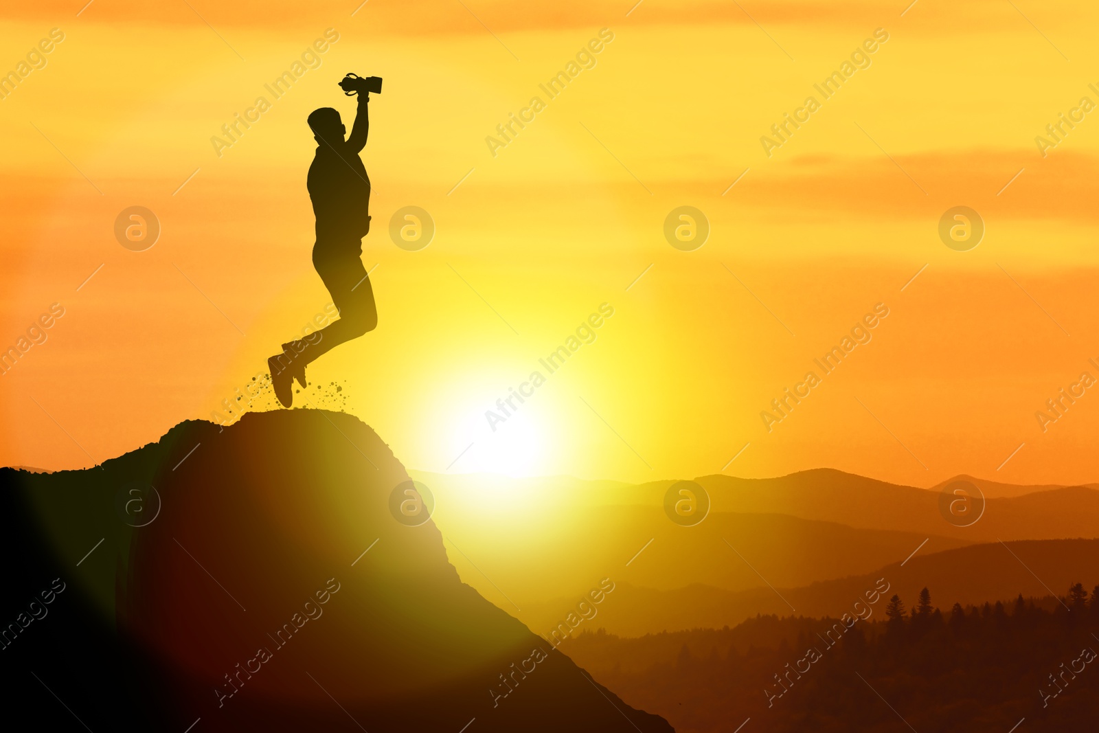 Image of Winner with trophy cup in mountains at sunrise