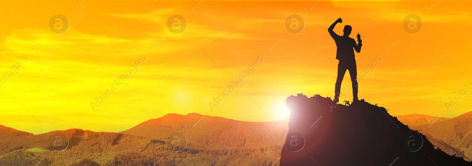 Image of Winner with trophy cup in mountains at sunrise. Banner design