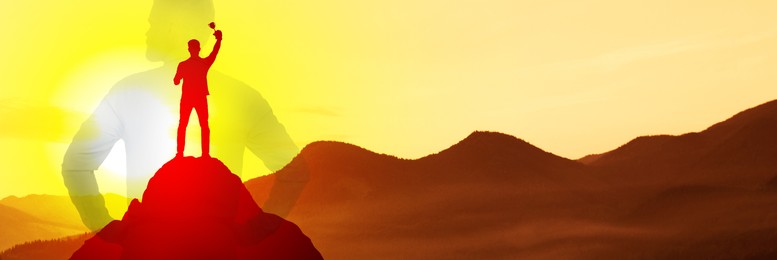 Winner with trophy cup in mountains at sunrise and silhouette of man. Banner design